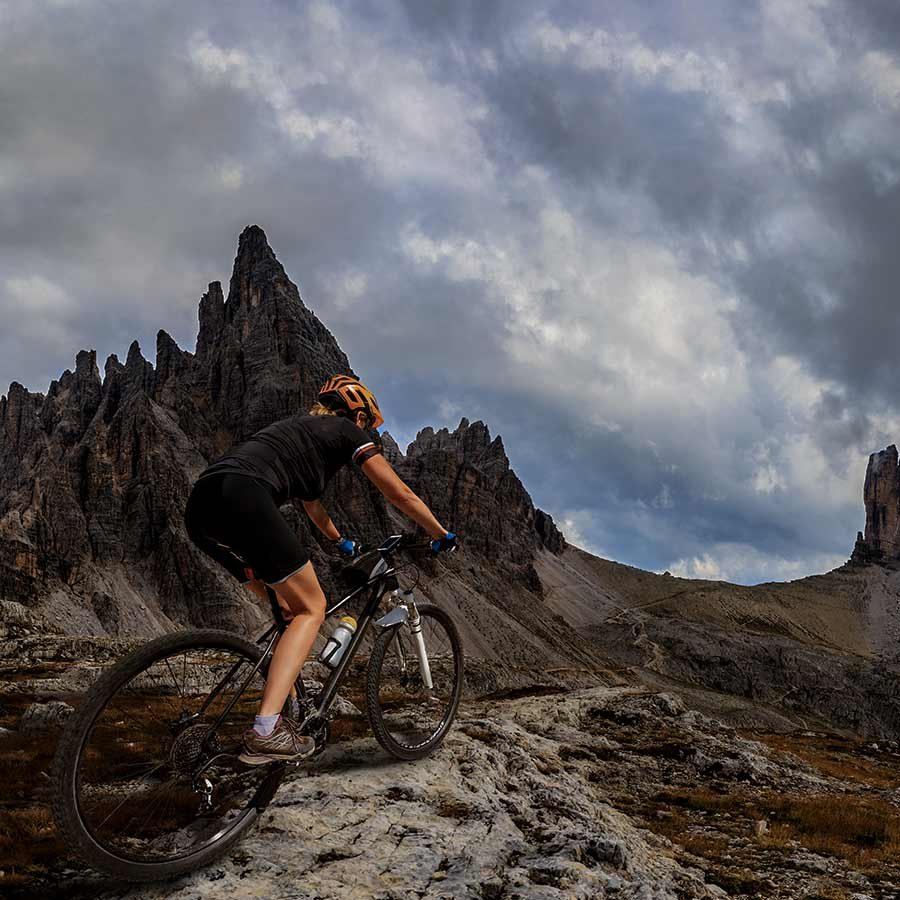 Chica montando en bicicleta de montana por un sendero