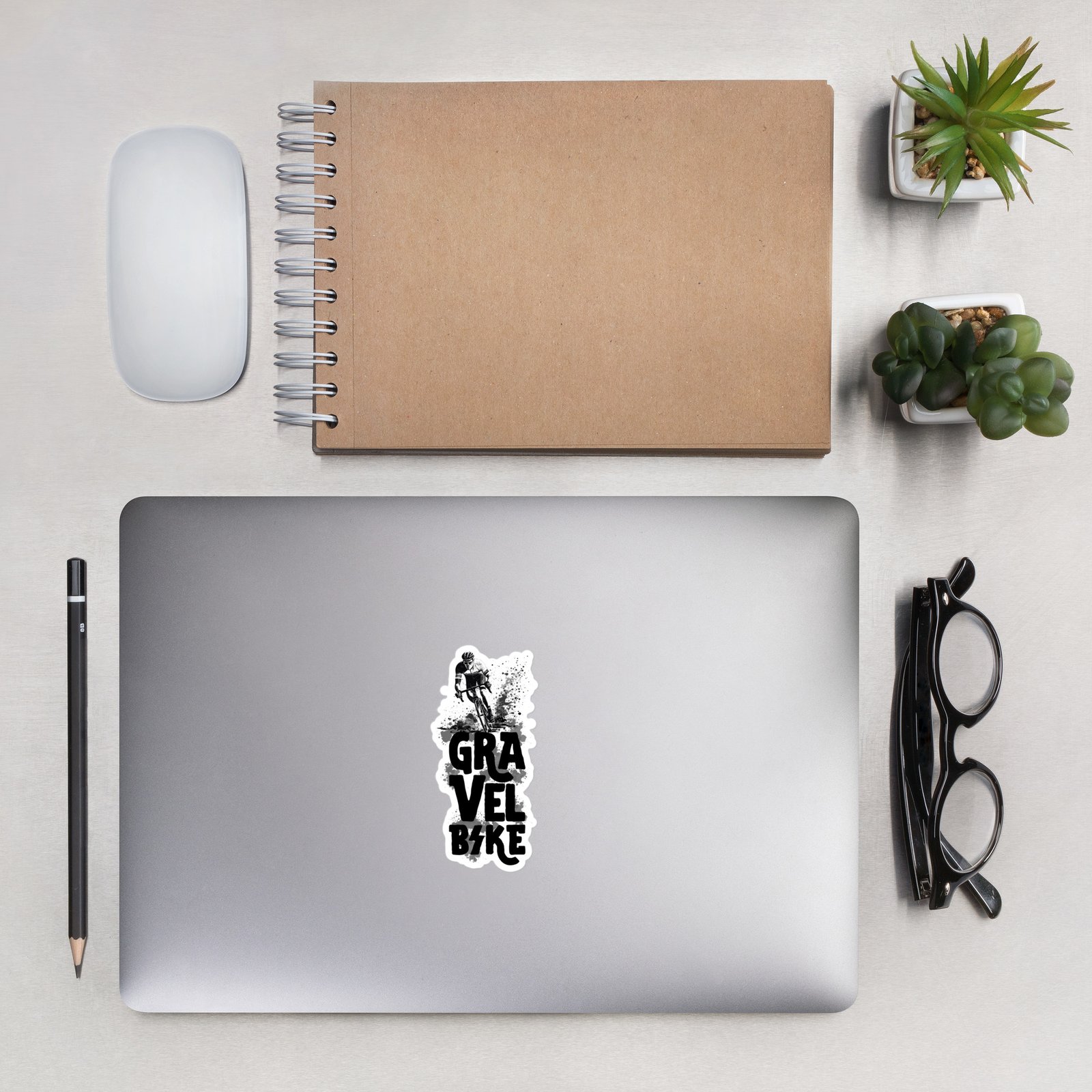 Pegatina Gravel Bike sobre ordenador en escritorio con gafas y cuaderno