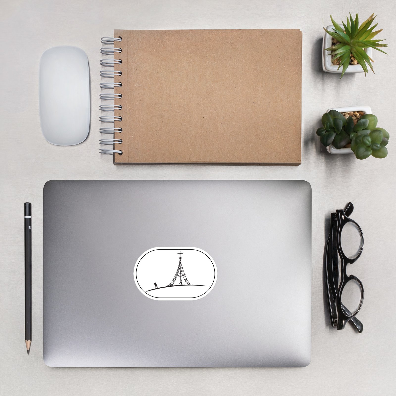 Pegatina Gorbeia sobre laptop en escritorio con gafas y cuaderno, ambiente trabajo moderno